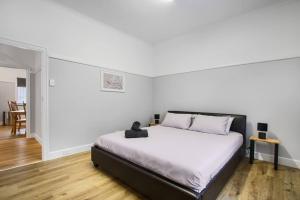 1 dormitorio con 1 cama grande en una habitación blanca en The Home Sweet Home, en Bairnsdale