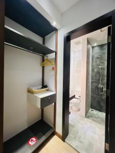 a bathroom with a walk in shower and a toilet at oxy suites 1-03 at Shop House Meisterstadt Pollux Habibie in Batam Center