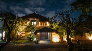 une maison la nuit avec des lumières devant elle dans l'établissement KUTA - 4BR Villa with Private XL Pool, à Kuta