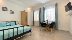 a bedroom with a bed and a table with chairs at EVU Long Street in Braşov