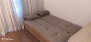 un divano marrone in un angolo di una stanza di Flat 4 Estrelas Pinheiros a San Paolo