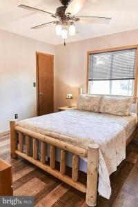 um quarto com uma cama de madeira e uma ventoinha de tecto em Pocono Vacation Retreat em Albrightsville