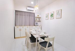 ein Esszimmer mit einem weißen Tisch und Stühlen in der Unterkunft 3 mins to Garden City & Kubota Jln Apas Homestay in Tawau
