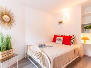 a bedroom with a bed with red pillows and a mirror at Appartement Saint-Lary-Soulan, 2 pièces, 4 personnes - FR-1-296-472 in Saint-Lary-Soulan