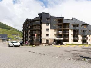 a large building with a car parked in front of it at Appartement Saint-Lary-Soulan, 2 pièces, 4 personnes - FR-1-296-472 in Saint-Lary-Soulan