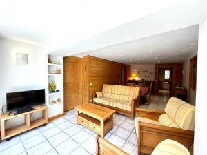 a living room with two couches and a tv at Appartement La Clusaz, 4 pièces, 8 personnes - FR-1-437-104 in La Clusaz