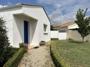 ein weißes Haus mit einer blauen Tür und einem Hof in der Unterkunft Maison spacieuse proche plage avec jardin et terrasse – 3 chambres, 6 couchages, calme assuré - FR-1-224-805 in Saint-Gilles-Croix-de-Vie
