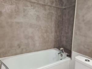 ein Badezimmer mit einer weißen Badewanne neben einem WC in der Unterkunft Appartement Cap d'Agde, 1 pièce, 2 personnes - FR-1-249-398 in Cap d'Agde