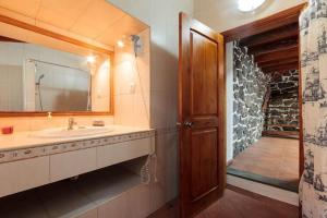 ein Bad mit einem Waschbecken und einem Spiegel in der Unterkunft holiday home, Praínha de Baixo, Pico, Azores in Prainha de Baixo