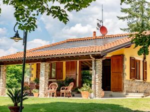 蒙特卡蒂尼泰爾梅的住宿－Cottage in Tuscany with private pool，黄色的房子,设有门廊和椅子