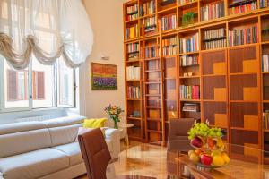 a living room with a couch and a table and bookshelves at Karisma Suites in Rome