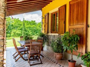 een patio met een tafel en stoelen en een raam bij Cottage in Tuscany with private pool and air conditioning in Montecatini Terme