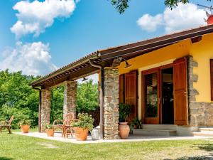 a stone house with a porch and patio at Cottage in Tuscany with private pool in Montecatini Terme