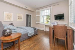 a living room with a couch and a table and a television at Les Suites KAISHI in Lévis