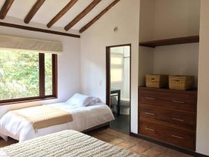 a bedroom with a bed and a dresser and a mirror at CASAMIGOS in Villa de Leyva