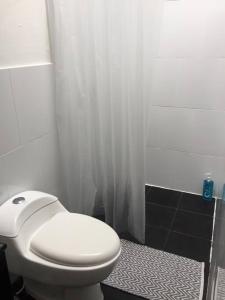 a bathroom with a white toilet and a shower at CASAMIGOS in Villa de Leyva