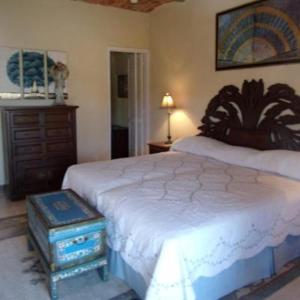 a bedroom with a large bed and a dresser at Casita Montana Hotel in Ajijic