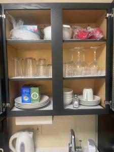 une armoire remplie de vaisselle, de verres et d'un lavabo dans l'établissement Ultimate Escape/Free Parking, à Houston