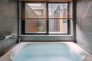 una bañera en un baño con ventana en 谷町君 星屋 離宮ノ宿 二条城, en Kioto
