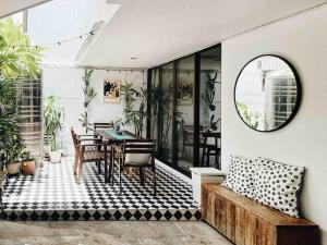 a patio with a table and chairs and a mirror at Pannarai's House in Bangkok