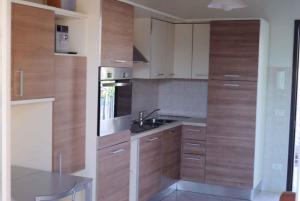 Una cocina con gabinetes de madera y un fregadero y una mesa. en Apartment in Marina di Massa - Toskana 24103, en Marina di Massa 4 fotos más