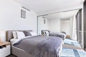 a bedroom with two beds and a large mirror at Exceptional Beach views - Luxury apartment in Newcastle