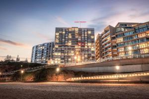 un grand bâtiment avec des lumières devant lui dans l'établissement Exceptional Beach views - Luxury apartment, à Newcastle