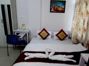 a bedroom with a bed with two white towels on it at Ashish Guest House, Goverdhan Vilas in Udaipur