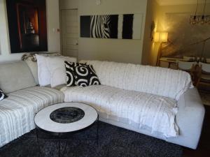 uma sala de estar com um sofá branco e uma mesa em Sunny 2 bed Restaurants beach at door Pets O.K em Sydney