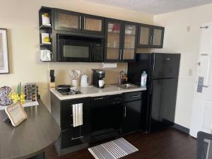 a kitchen with a black refrigerator and a table at Luxurious Escape FREE PARKING in Houston