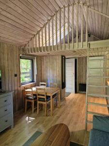 a room with a table and a loft bed at Hytte Narie 2 in Bogaczewo