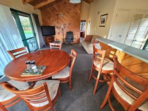 sala de estar con mesa de madera y sillas en Kiwi Park Motels, en Murchison