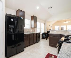 - Cocina grande con nevera negra en Select Exclusive Room in Fresno Texas, en Fresno