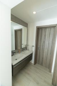 ein Badezimmer mit einem Waschbecken und einem großen Spiegel in der Unterkunft Playa Coral Condo in Paradise F22 in Punta Cana