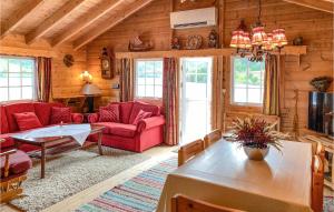 uma sala de estar com mobiliário vermelho num chalé de madeira em Nice Home In Selje With Wifi em Stokke