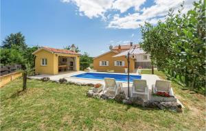 a yard with two chairs and a swimming pool at Awesome Home In Sv,petar U Sumi With Kitchen in Sveti Petar u Šumi