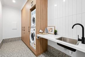 a kitchen with a sink and a washing machine at City Edge 2 Apartment - Wheelchair Accessible in Mount Gambier