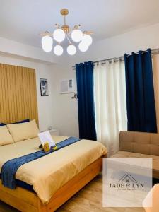 - une chambre avec un lit doté de rideaux bleus et d'un lustre dans l'établissement Your home away from home, at the heart of Bacolod., à Bacolod