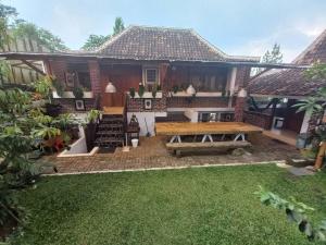 ein Haus mit einem Picknicktisch im Hof in der Unterkunft Villa Sajodo [Hilltop Get Away w/ Valley View] in Bandung