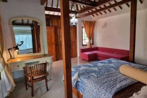 ein Schlafzimmer mit einem Bett, einem Spiegel und einem Sofa in der Unterkunft Villa Sajodo [Hilltop Get Away w/ Valley View] in Bandung