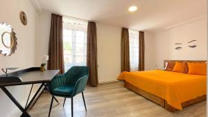 a bedroom with a bed and a desk and a table at WELL Prettyplaces Apartment 001 in Braşov