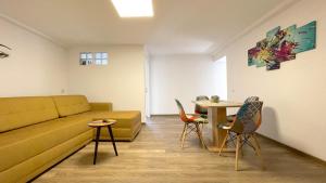 a living room with a couch and chairs and a table at WELL Prettyplaces Apartment 001 in Braşov