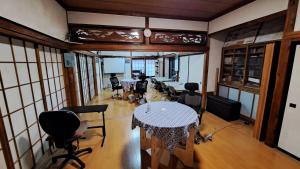 um quarto com uma mesa e cadeiras em Shino's Farm Inn em Azumino