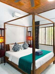 a bedroom with a four poster bed with a wooden canopy at Birdcage Boutique in Phnom Penh