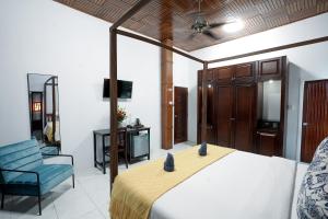 1 dormitorio con 1 cama y 1 silla azul en Birdcage Boutique, en Phnom Penh