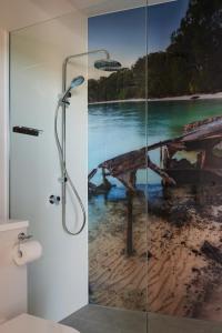 a bathroom with a shower with a painting of a pier at Beer n Bed - Brewery Custodian for the Night in Dunwich