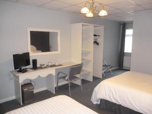 a bedroom with a desk with a computer on it at 5 Corners Guest Inn in Ballyclare