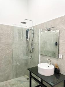 a bathroom with a sink and a glass shower at Birdcage Boutique in Phnom Penh