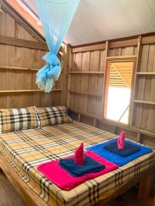 ein Zimmer mit einem Bett mit zwei Handtüchern darauf in der Unterkunft Toh Tao Homestay 