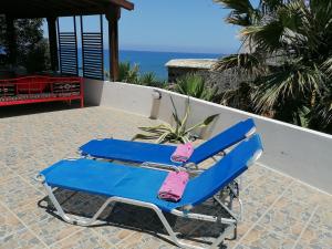 a blue beach chair with a pink towel on it at Shambala Beach House-where mountains meet the sea in Pomos